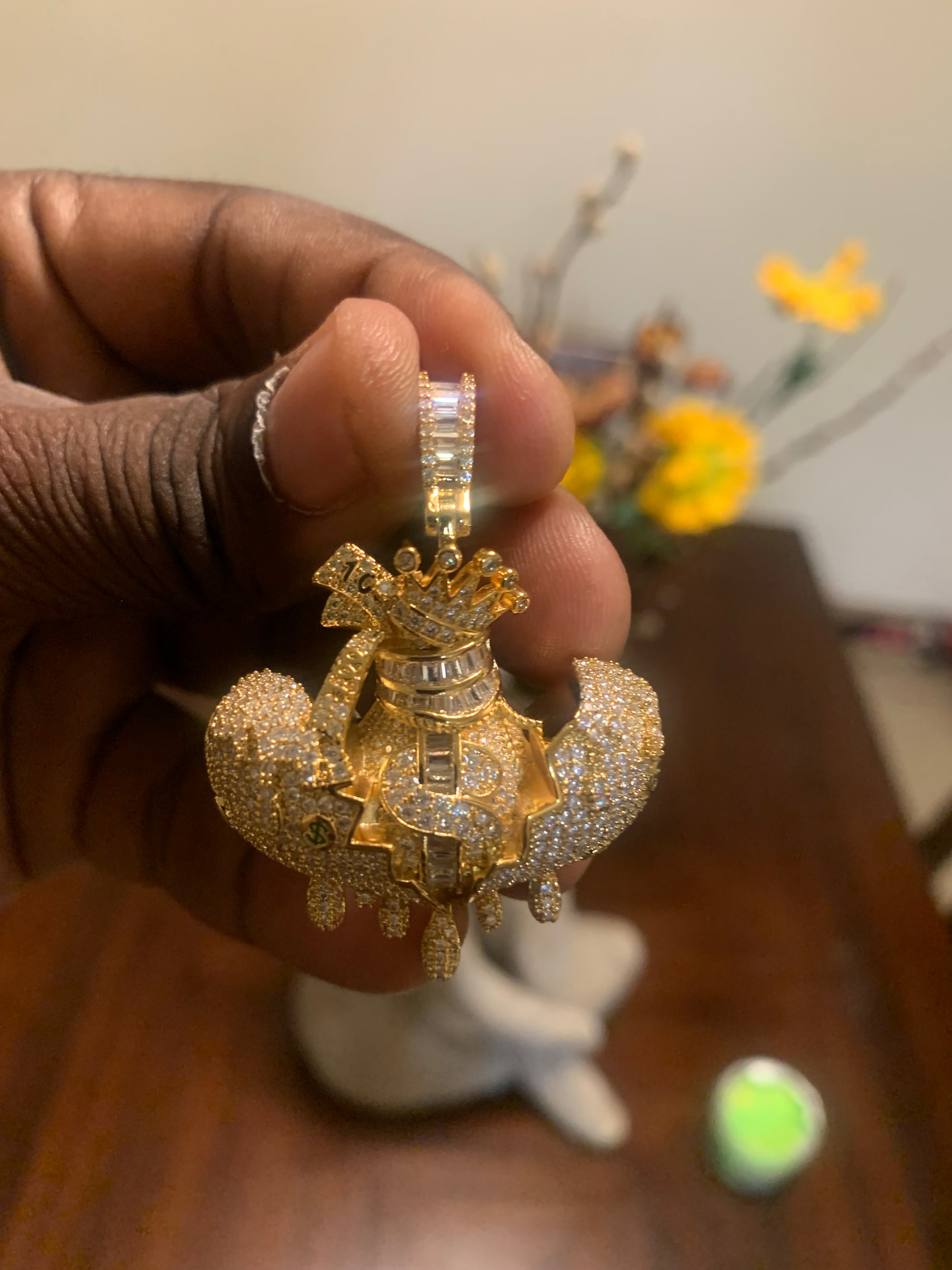 Gold-tone iced money bag pendant with crown and dollar sign