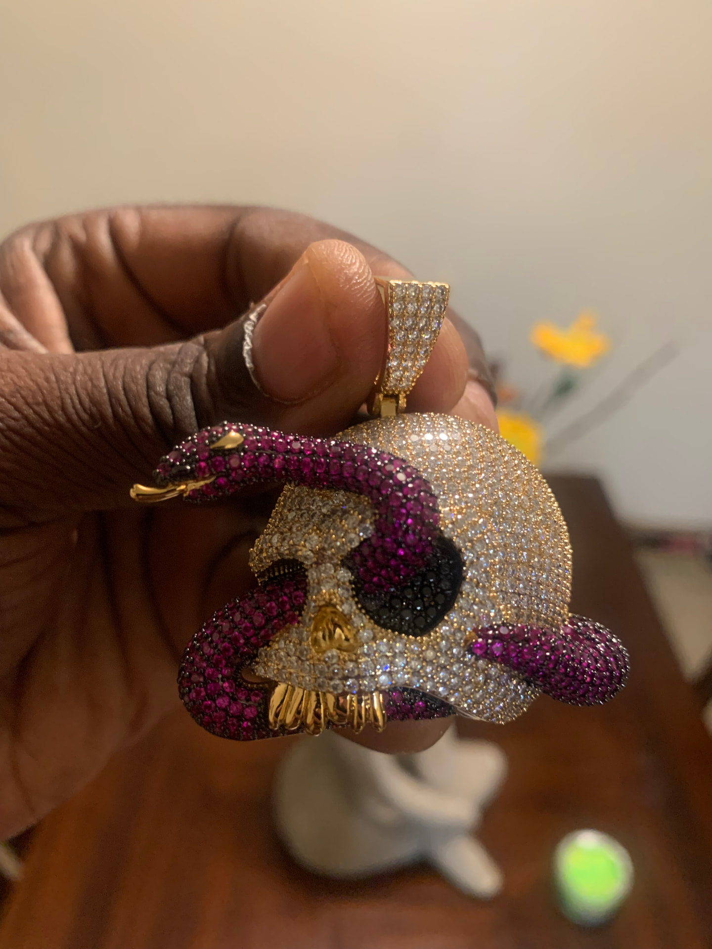 Gold skull pendant wrapped by a purple iced snake