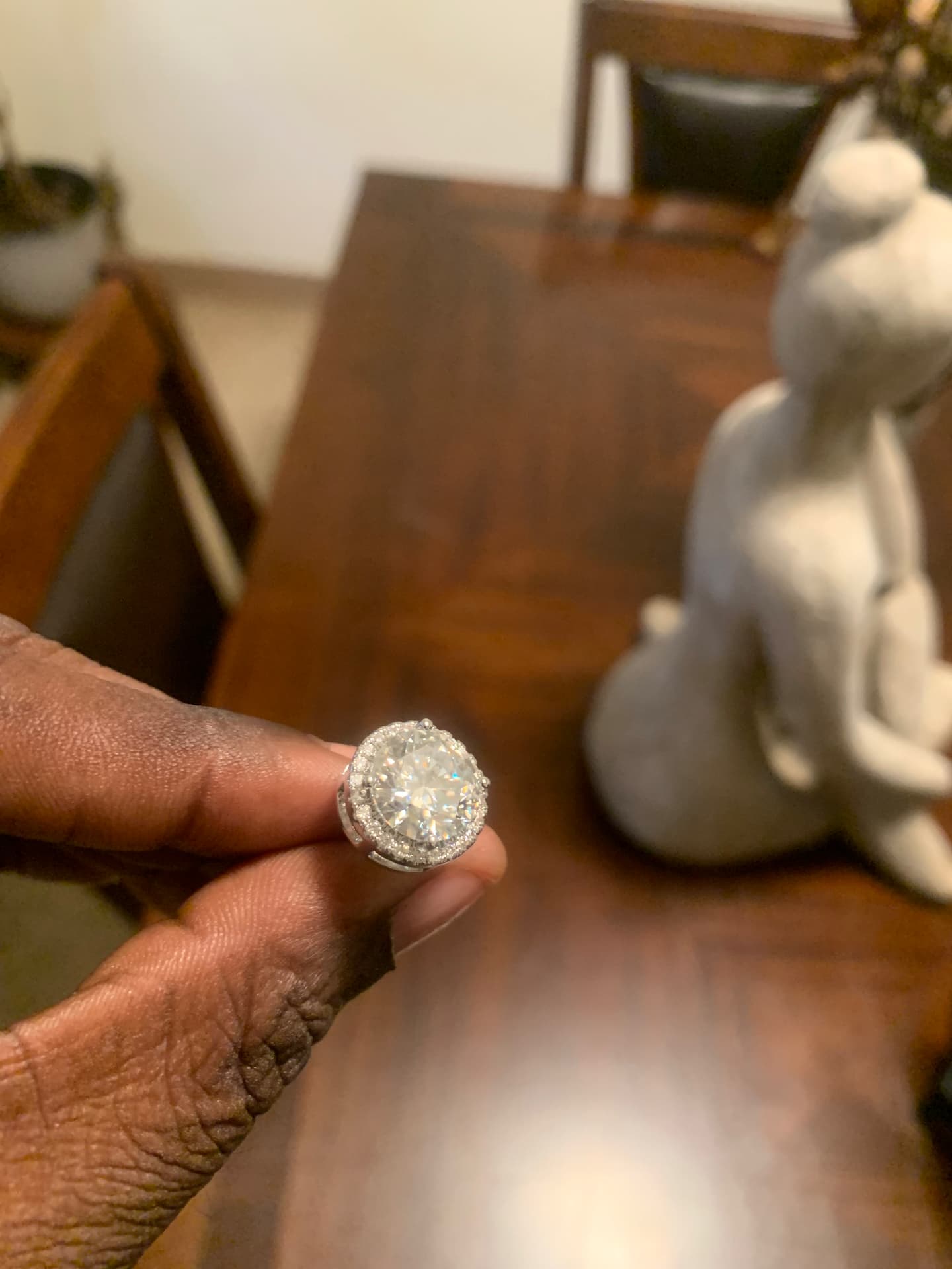 Angled view of one round moissanite halo stud